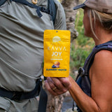 attractive-older-couple-hiking-holding-joy-kavva-delta-9-thc-gummies-packaging-kavva-2023